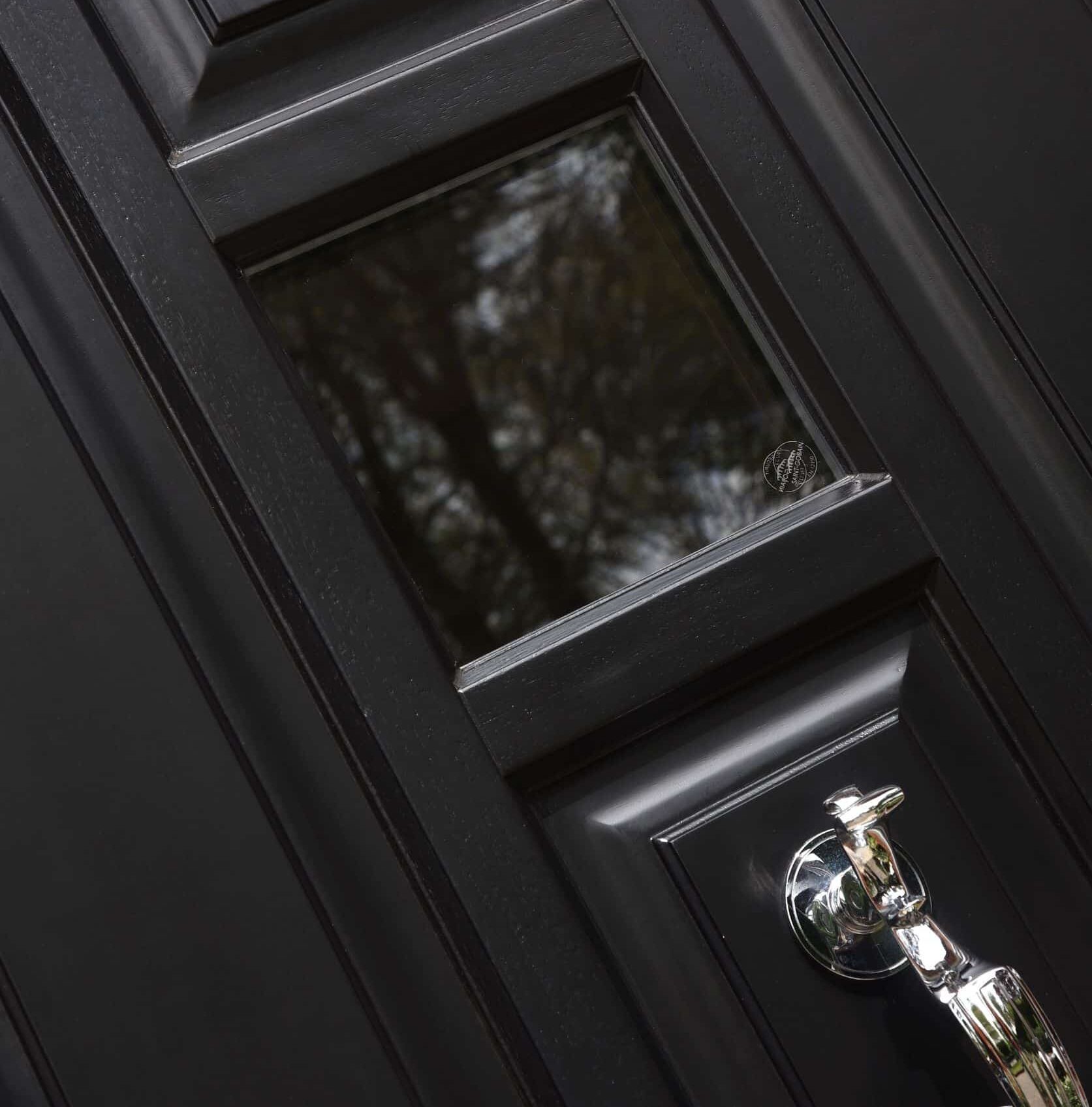 Black Timber Entrance Door - close up of raised and fielded panels, small window and arch detailing