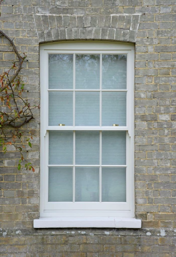 Timber sash window with astragal bars in white