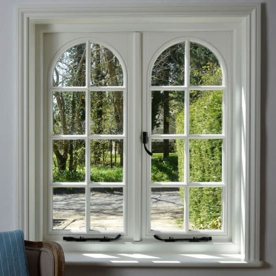 Cottage flush casements in off-white with 18mm astragal bars and true arch swept heads