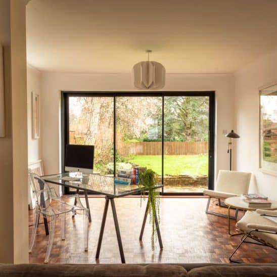 Sunflex aluminium sliding doors with flush threshold in graphite black matt finish (RAL 9011) with rectangular powder coated feature handle and 30mm interlock.