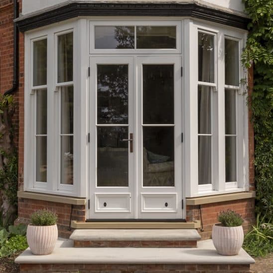 Bardwell timber French doors with 18mm astragal bars, with timber slim sash windows either side