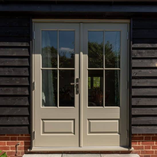 'Bardwell' timber French doors in French Grey with 18mm glazing bars and a raised and fielded door panel. Newbury polished nickel lever handle