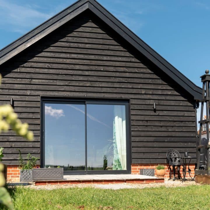 Timber clad annex with an aluminium sliding Sunflex patio door with super slim 20mm interlock maximising the view