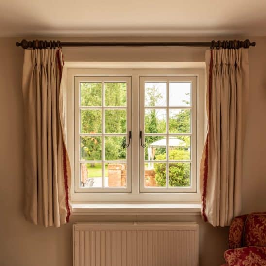 Evolution PVCu Timber Alternative casement windows in white with slim glazing bars black monkeytail handles