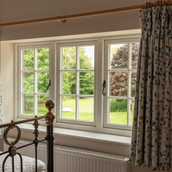 Evolution PVCu Timber Alternative casement windows in white with slim glazing bars black monkeytail handle