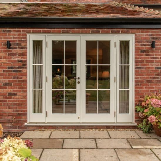 Timber French doors in Wimborne White Farrow & Ball colour match, with 18mm astragal bars and Samuel Heath antique brass unlacquered contour handle
