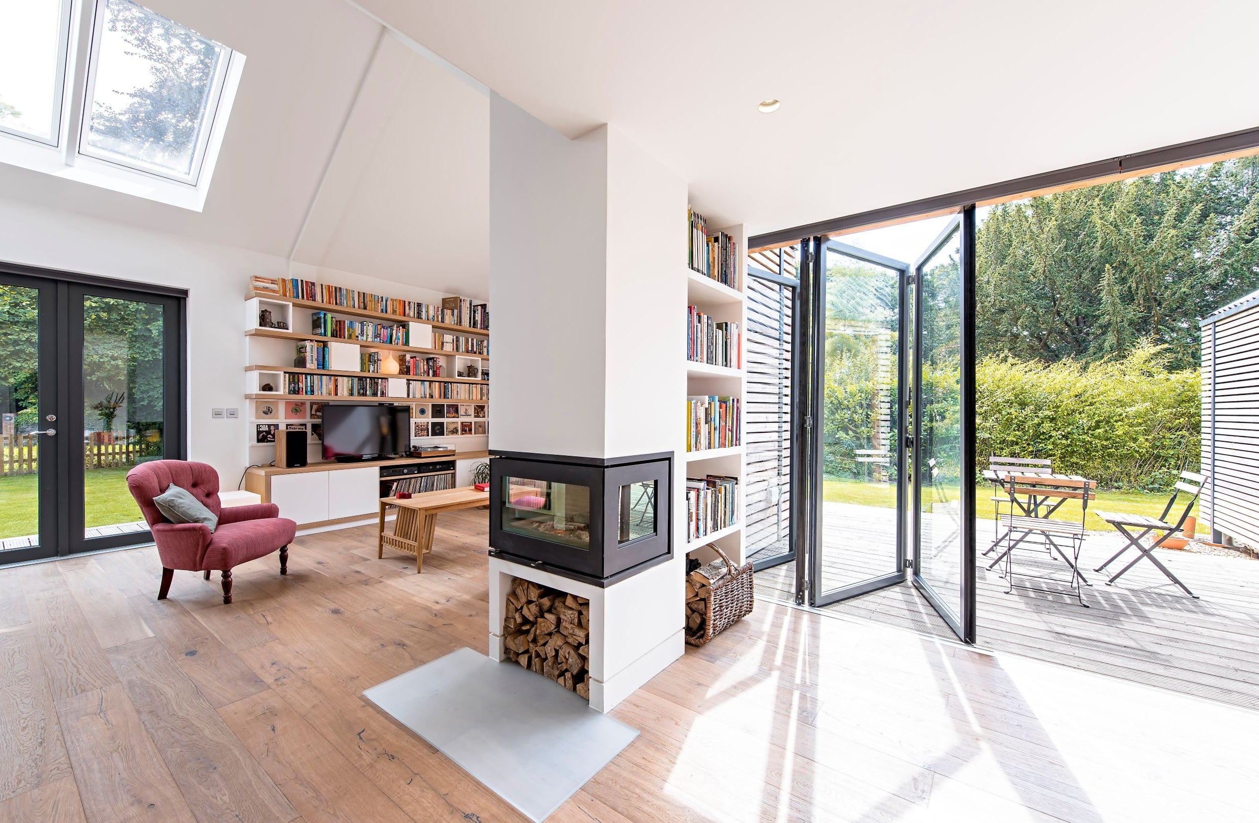 Partially open sunflex black bifold doors in a lounge settting