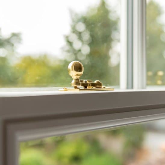 White timber sash window with polished nickel sash catch