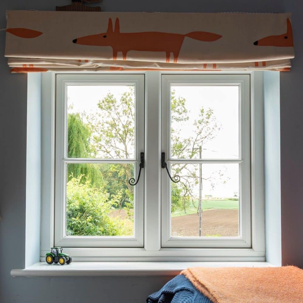 Evolution PVCu white casement windows with a single, slim glazing bar and black monkeytail handles