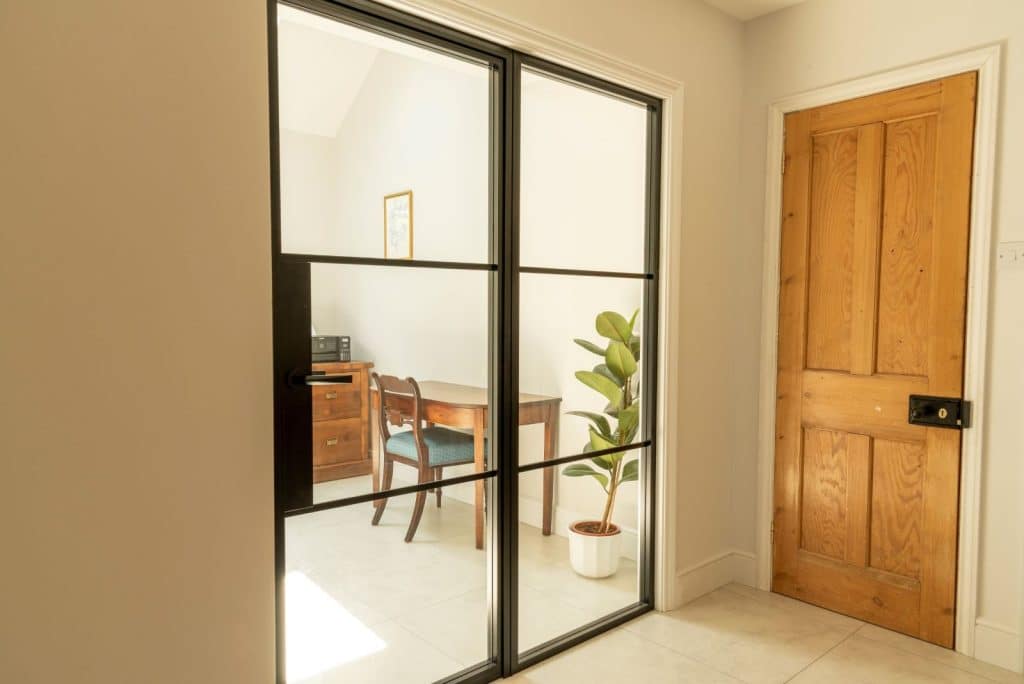 Aluco aluminium steel look internal glazed door with side panel, super slim 20mm glazing bars and Leon handle in matt Black