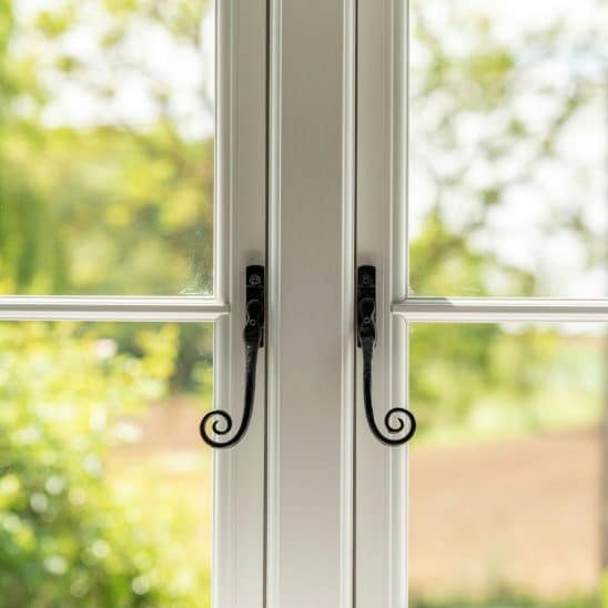 Evolution PVCu flush casement window with a single horizontal Georgian bar and black monkeytail handles. Olive Grey on the outside, white on the inside.