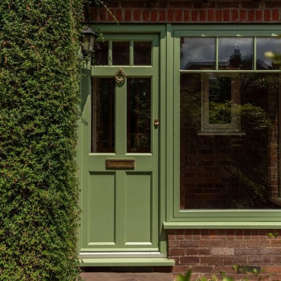 Evolution Ballingdon PVCu entrance door with brass ring door knocker, flush letterbox and escutcheon, and fixed side window with slim glazing bars