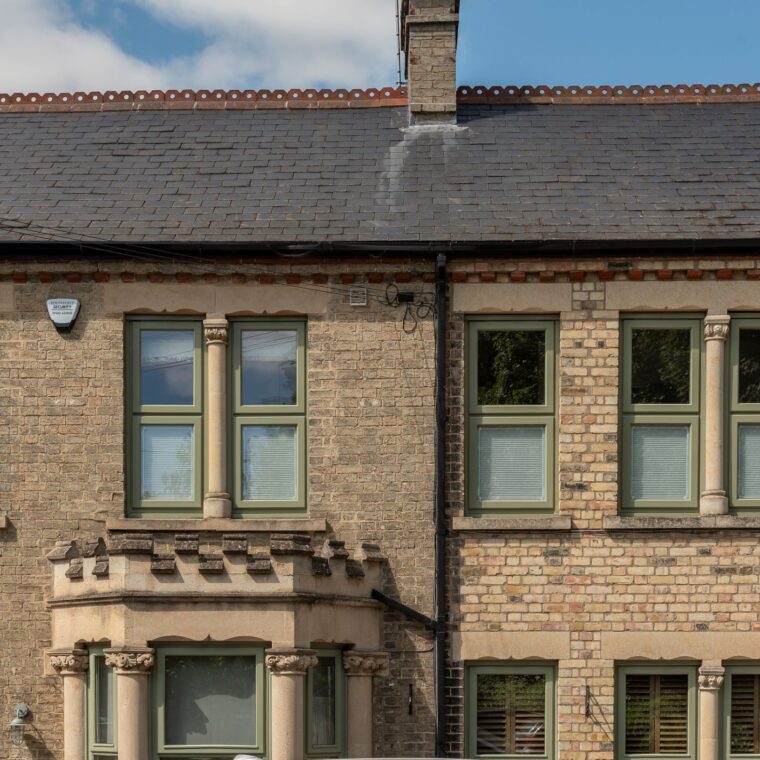 Engineered timber bottom opening casement windows in Green against traditional brickwork