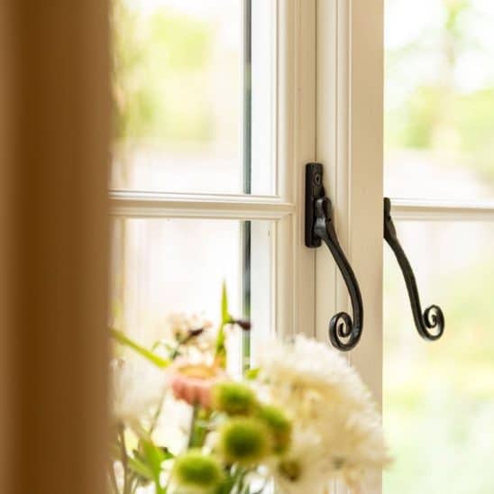 Evolution PVCu flush casement window with a single horizontal Georgian bar and black monkeytail handles. Olive Grey on the outside, white on the inside.