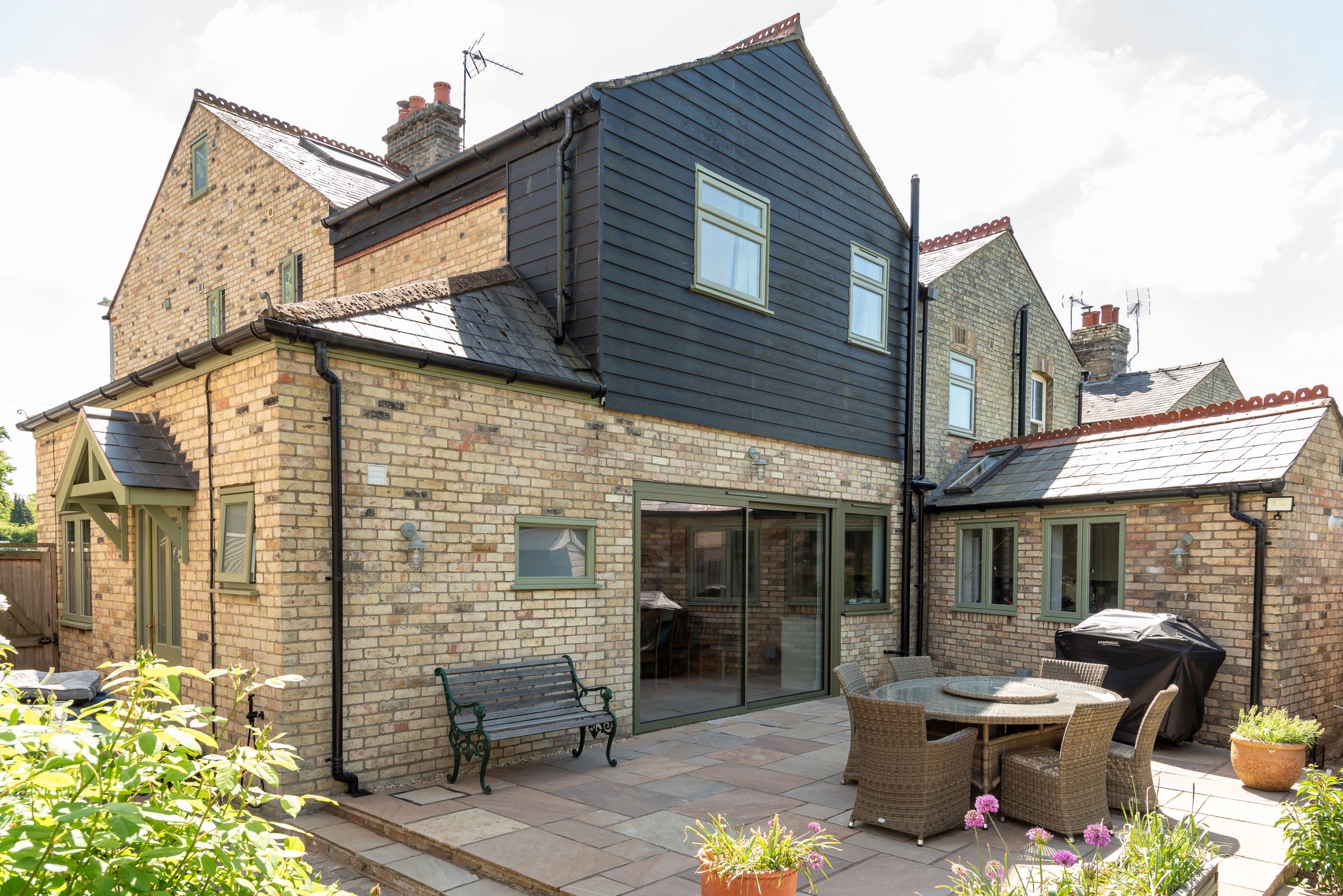 Engineered timber casement windows and Kingston entrance door with Sunflex SVG30 aluminium sliding door and side window, all in Green RAL 6021.