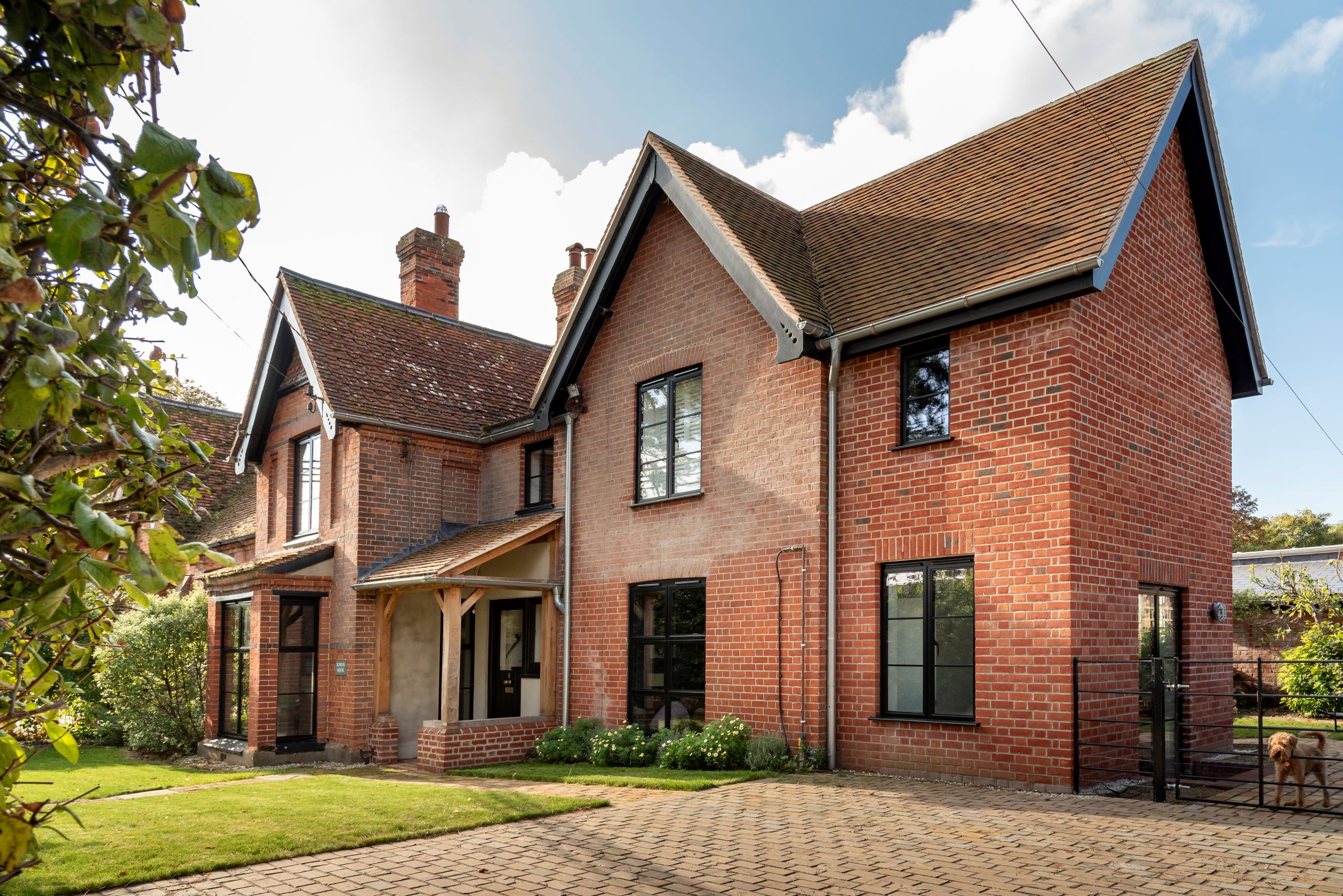 Red brick house with Art Deco black aluminium windows and patio doors