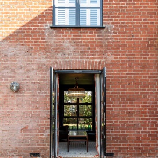 Red brick house with Art Deco black aluminium windows and patio doors