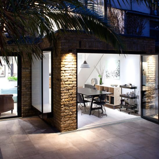 Sunflex aluminium Bifold doors open at night with matching single door