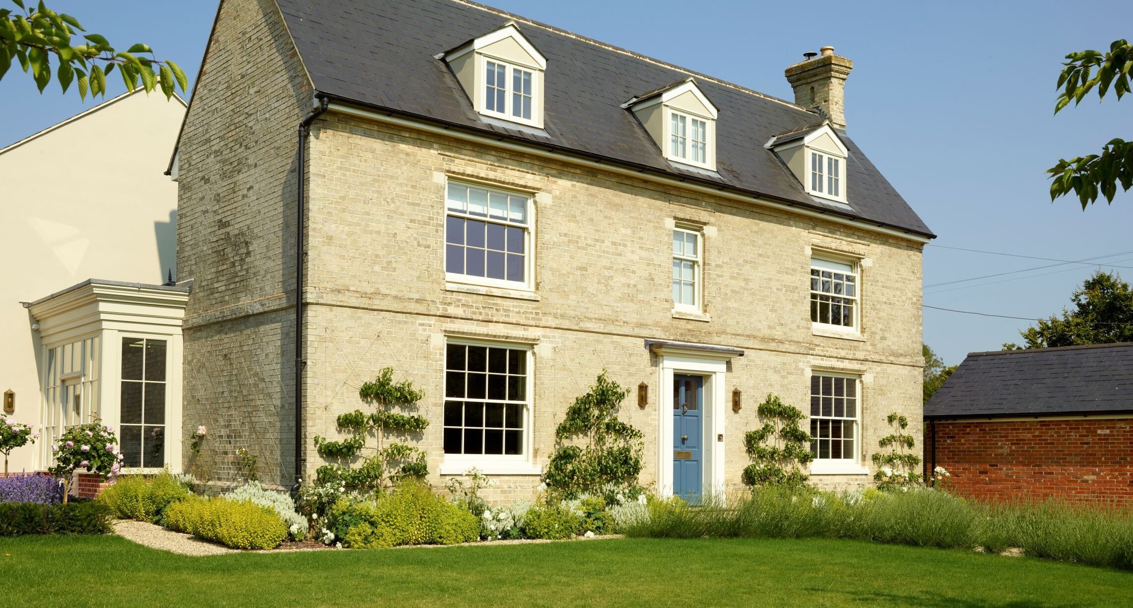 Slim timber sash windows in Farrow & Ball Slipper Satin and Chalfont timber entrance door in Farrow & Ball Stiffkey Blue