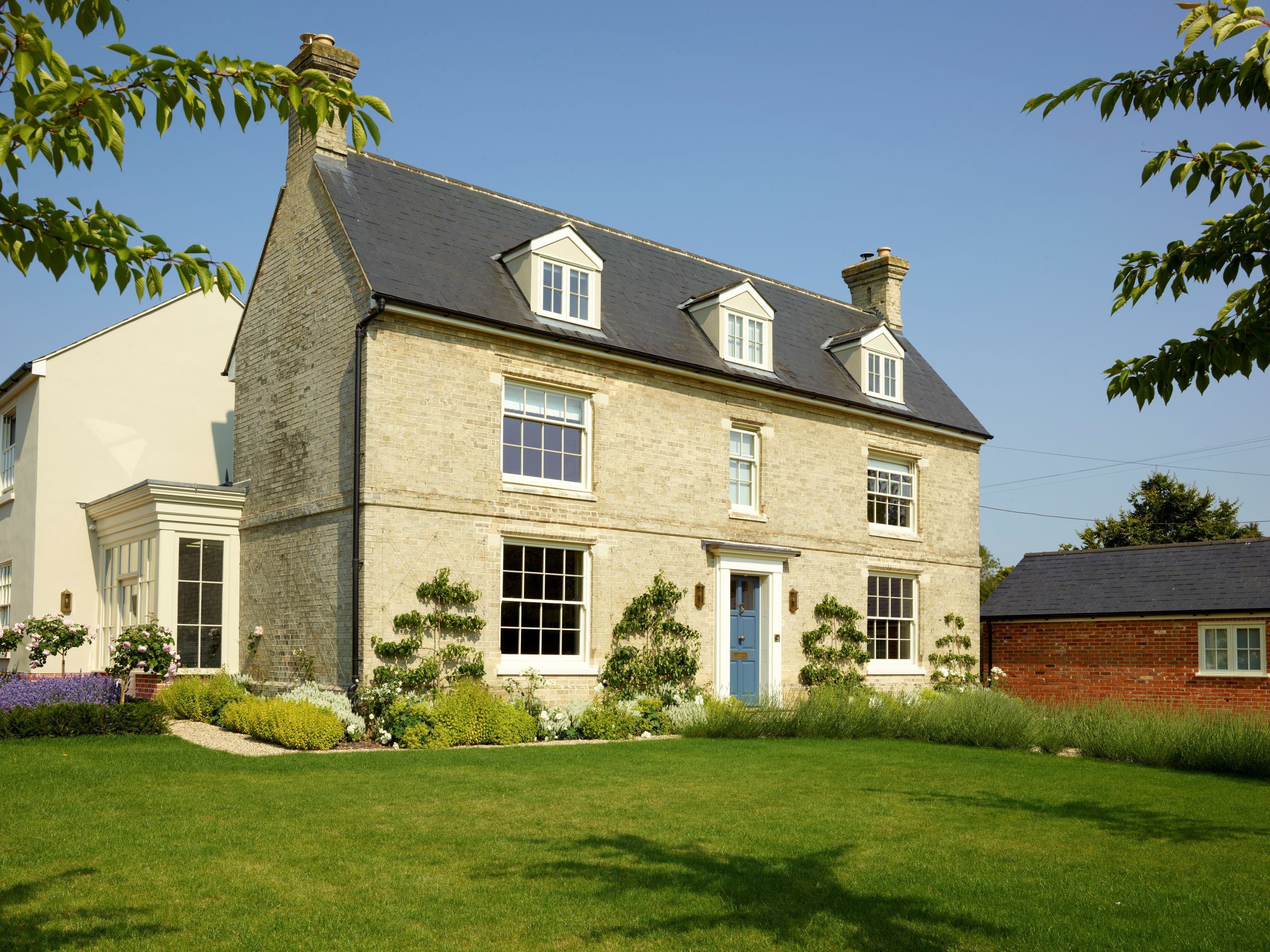 Slim timber sash windows in Farrow & Ball Slipper Satin and Chalfont timber entrance door in Farrow & Ball Stiffkey Blue