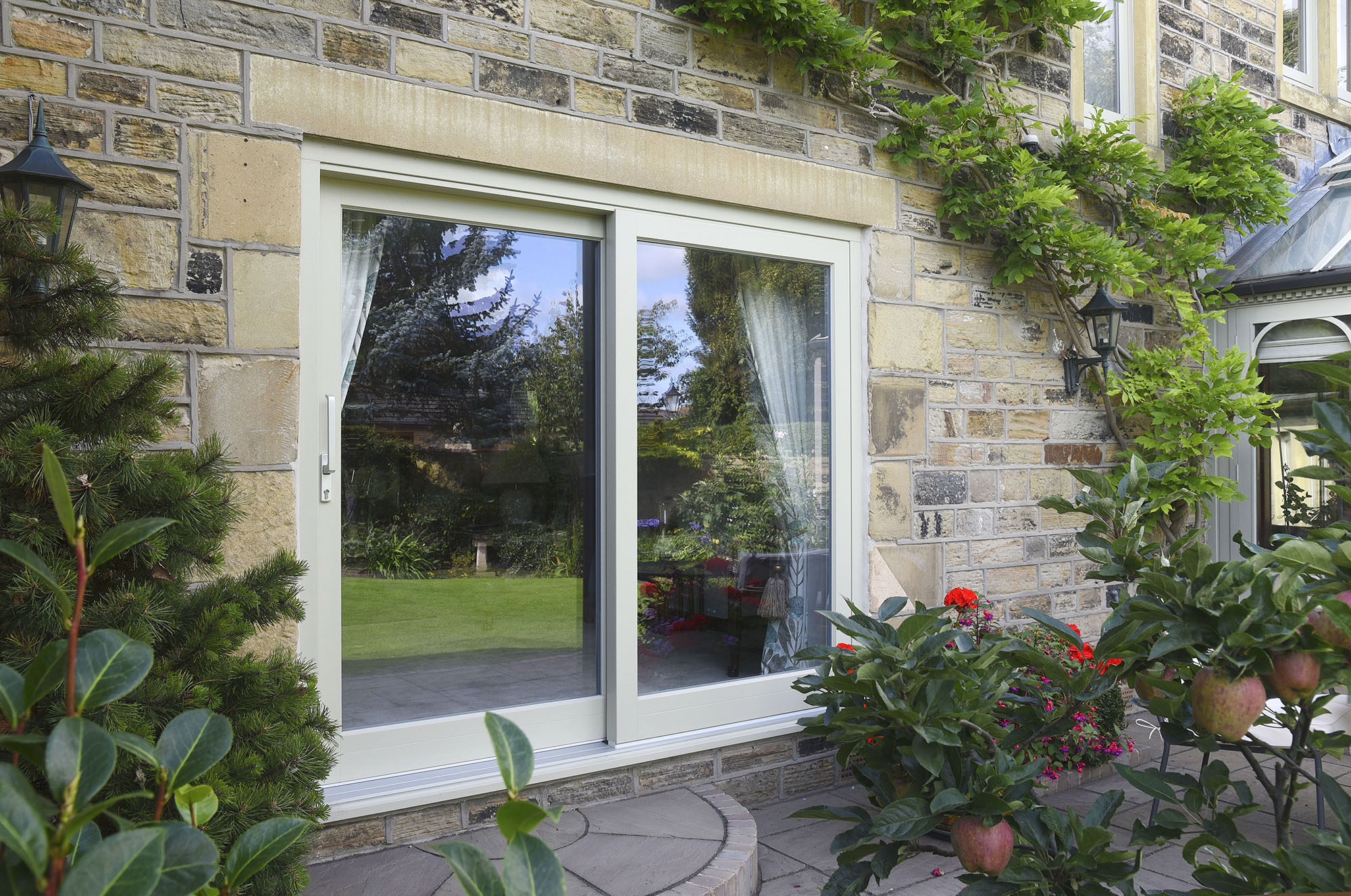 timber sliding doors in a stone traditional house with plants and creeper