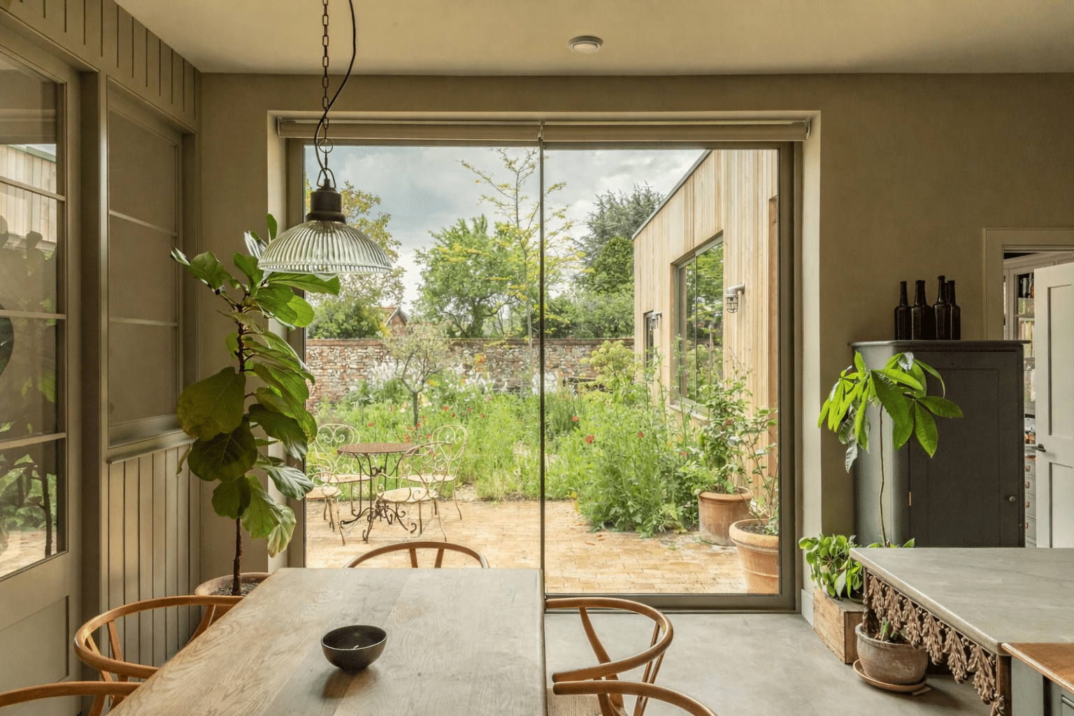 2.8 metre high Sunflex SVG20 aluminium sliding doors in Olive Grey with 20mm sightlines and flush stacking panels. Fitted blinds that operate independently for each panel have been installed by the owners.