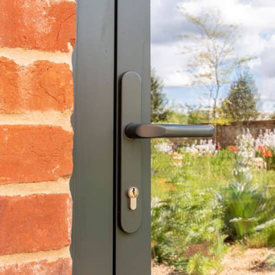 Sunflex aluminium lever handle, perfectly colour matched to the door and frame in Anthracite Grey