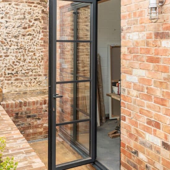 Our Heritage style aluminium bifold doors allow Tim's studio to be completely opened to outside. Choosing an odd number of panels (3 in this case) means Tim also has a highly effective single panel back door, securely fixing to the adjoining panel with the Sunflex patented locking panel catch.