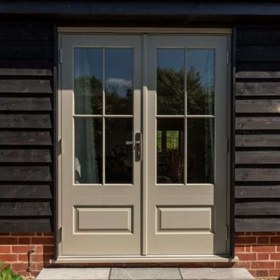 'Bardwell' timber French doors in French Grey with 18mm glazing bars and a raised and fielded door panel. Newbury polished nickel lever handle